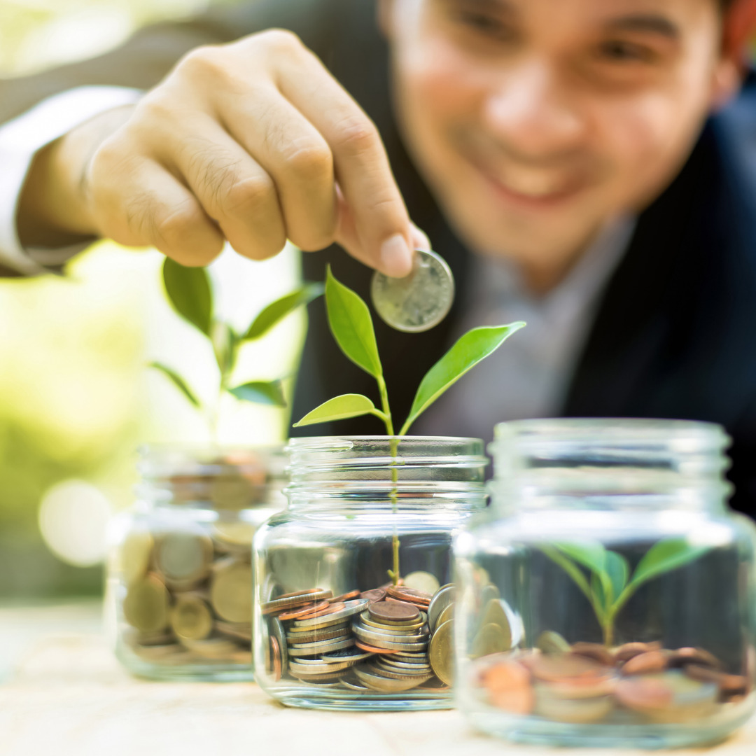 Man adding coin to jar