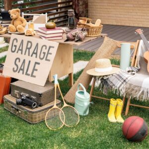 Items for sale with garage sale sign in front of items