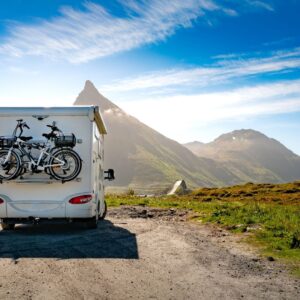 RV on road with mountains in background