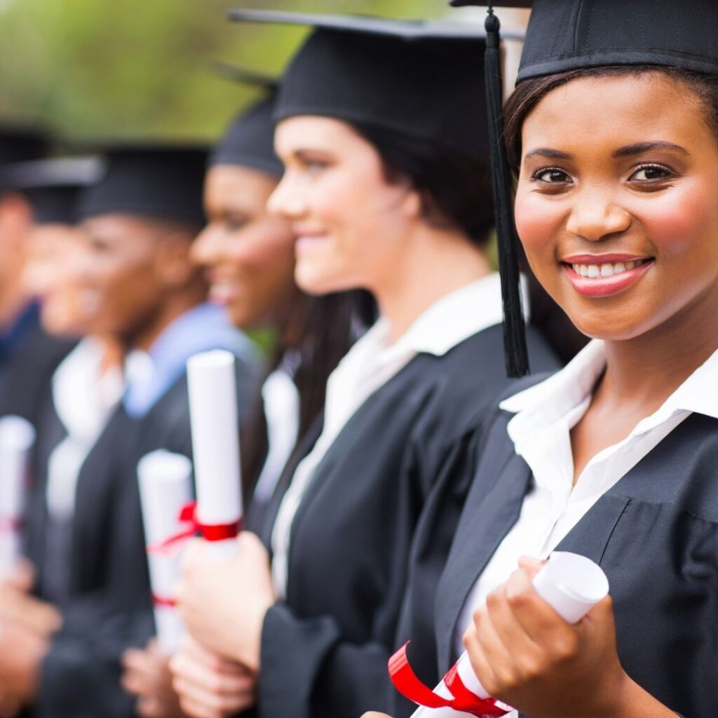 Woman in cap and gown holding college degree