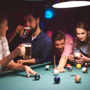 Friends playing pool and drinking beer