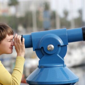 Person looking through blue telescope