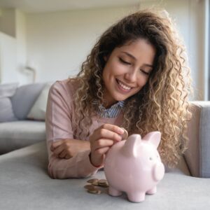 Woman putting money into piggybank